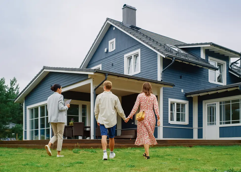 People walking towards a blue house.